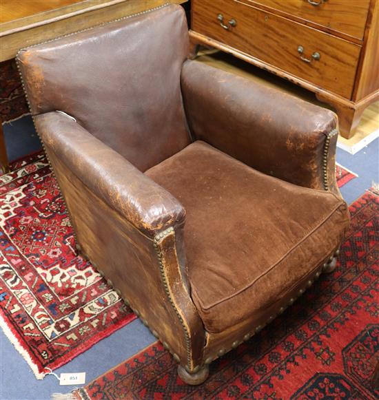 A near pair of early 20th century leather club armchairs, one seat cushion lacking